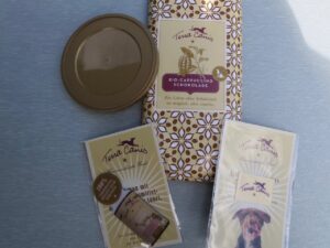 Schokolade, ein Einkaufswagenchip, ein Putztuch und ein Deckel für Hundefutterdosen